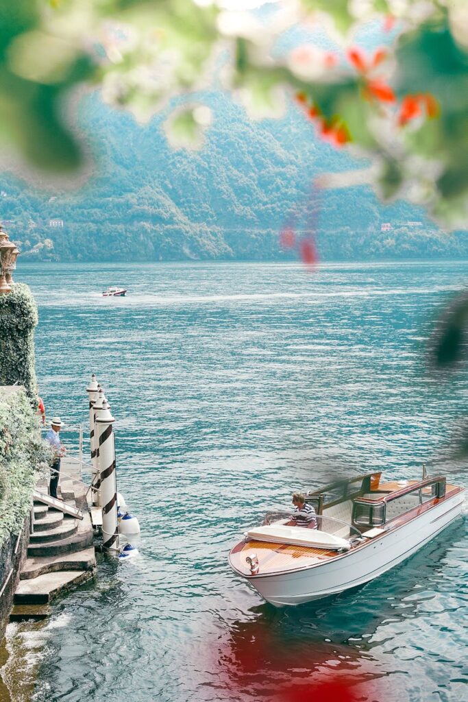 Scenic view of nautical transport on ocean against green mount and unrecognizable male traveler on stairs