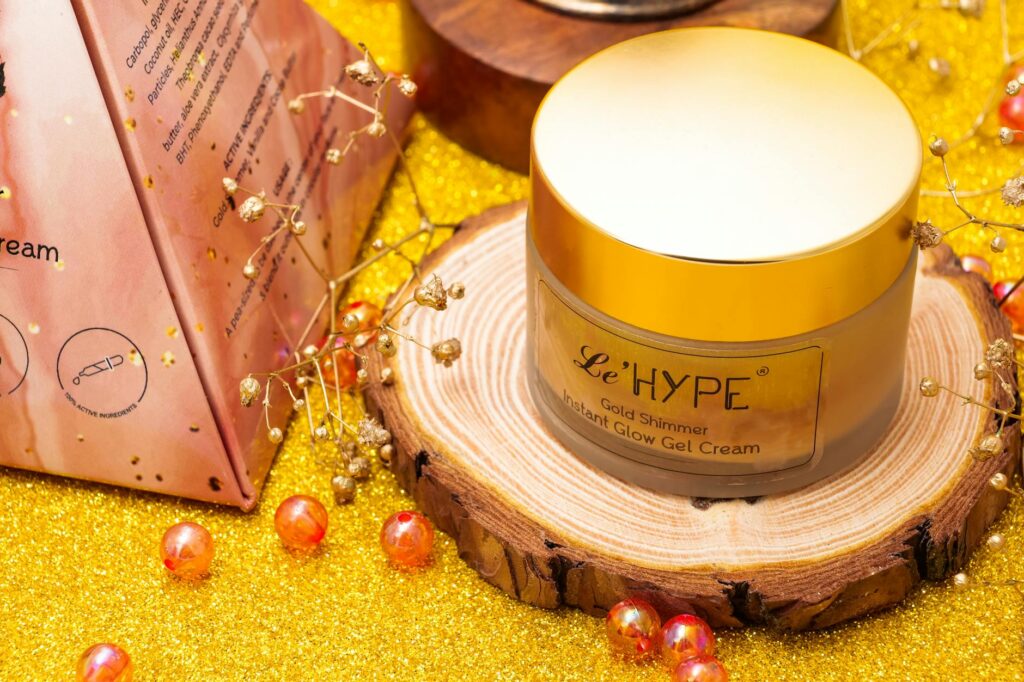 Gold shimmer gel cream showcased on a wooden stand with a glittery background, highlighting luxury and elegance.