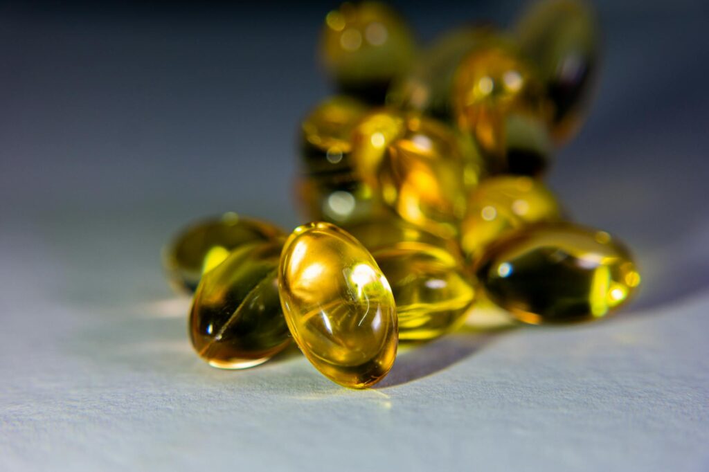 Vibrant close-up of golden softgel capsules, perfect for health-related content.