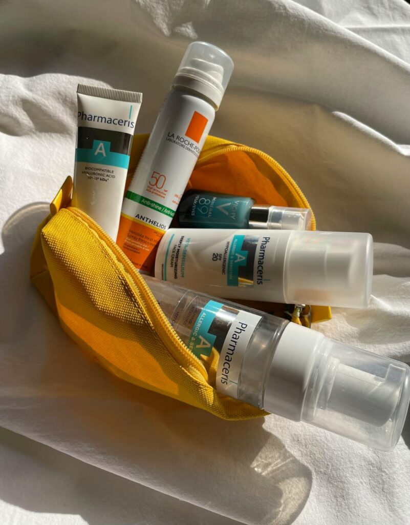 Assorted skincare products in a yellow pouch, captured in natural lighting.